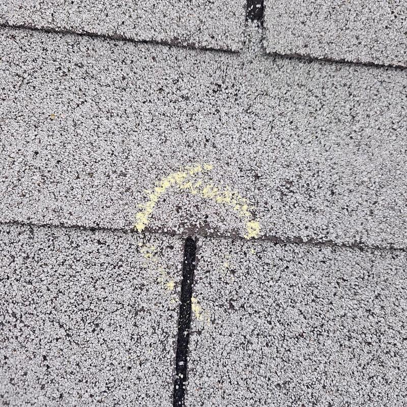 Asphalt shingle roof with hail damage marked in yellow Asphalt shingle roof with hail damage marked in yellow