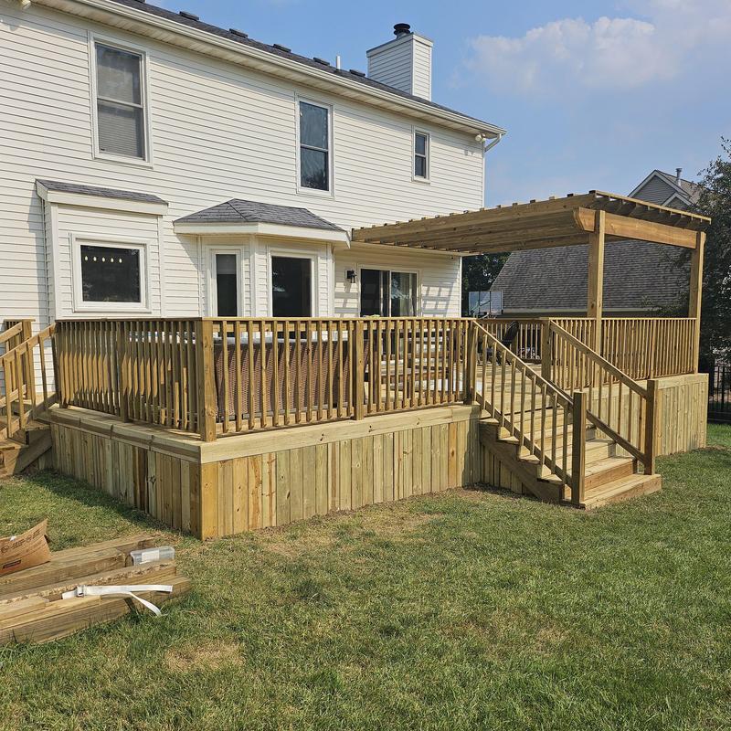 Treated wooden deck with pergola and railing system Treated wooden deck with pergola and railing system