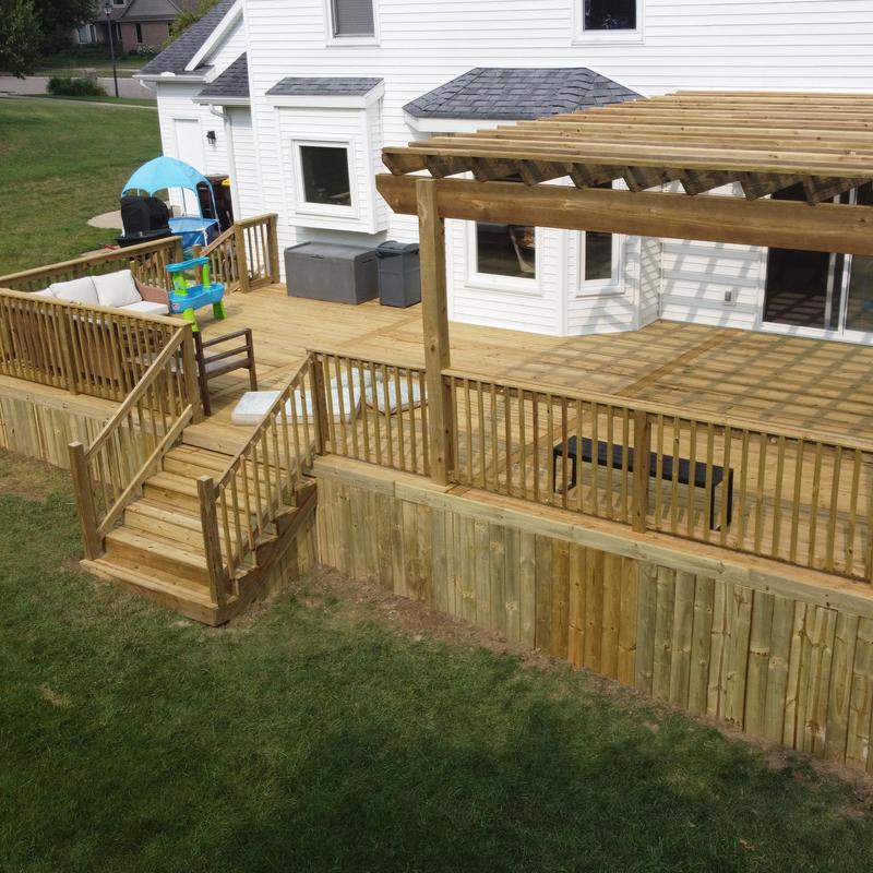 Treated wooden deck with pergola and railing system Treated wooden deck with pergola and railing system