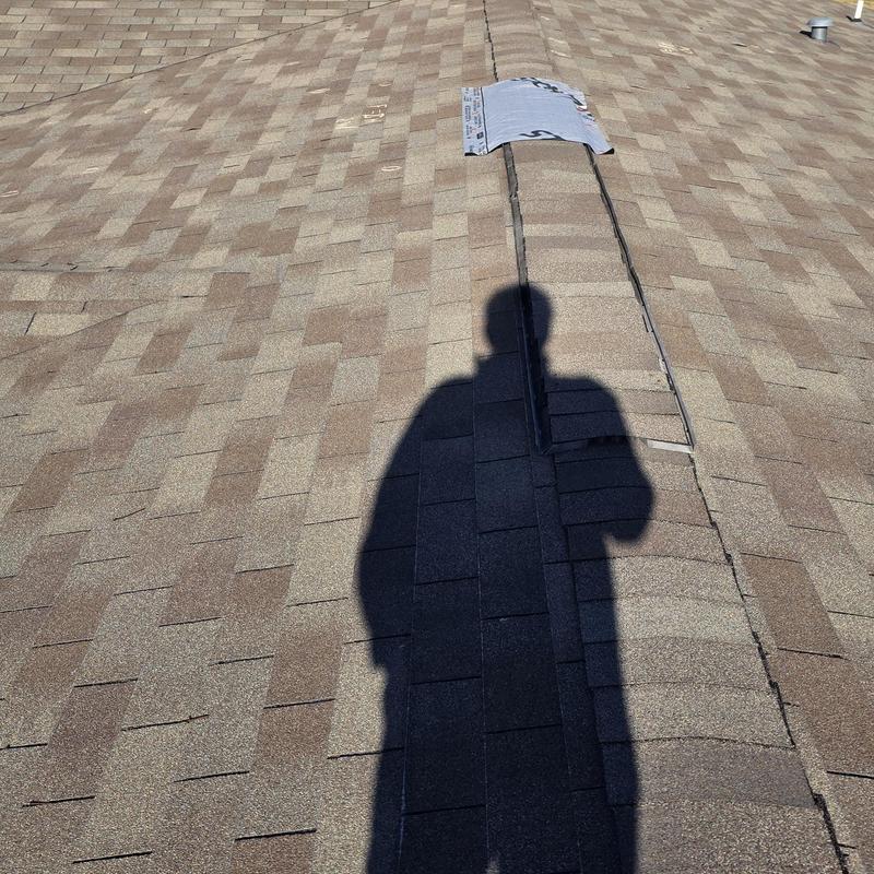 Roof ridge shingles with inspection markings and shadow