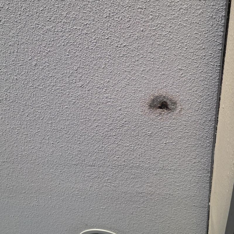 Ceiling drywall hole with burn mark damage