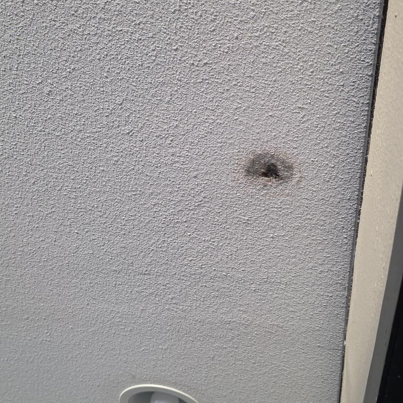 Stucco exterior wall hail damage close-up spot