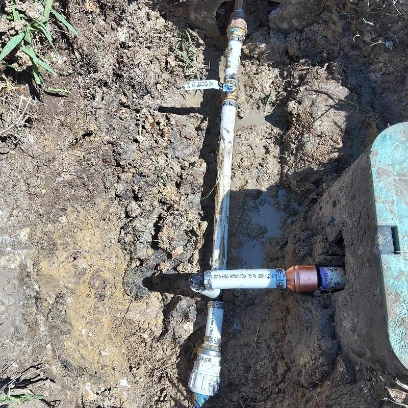 PVC water line with new ball valve in yard trench