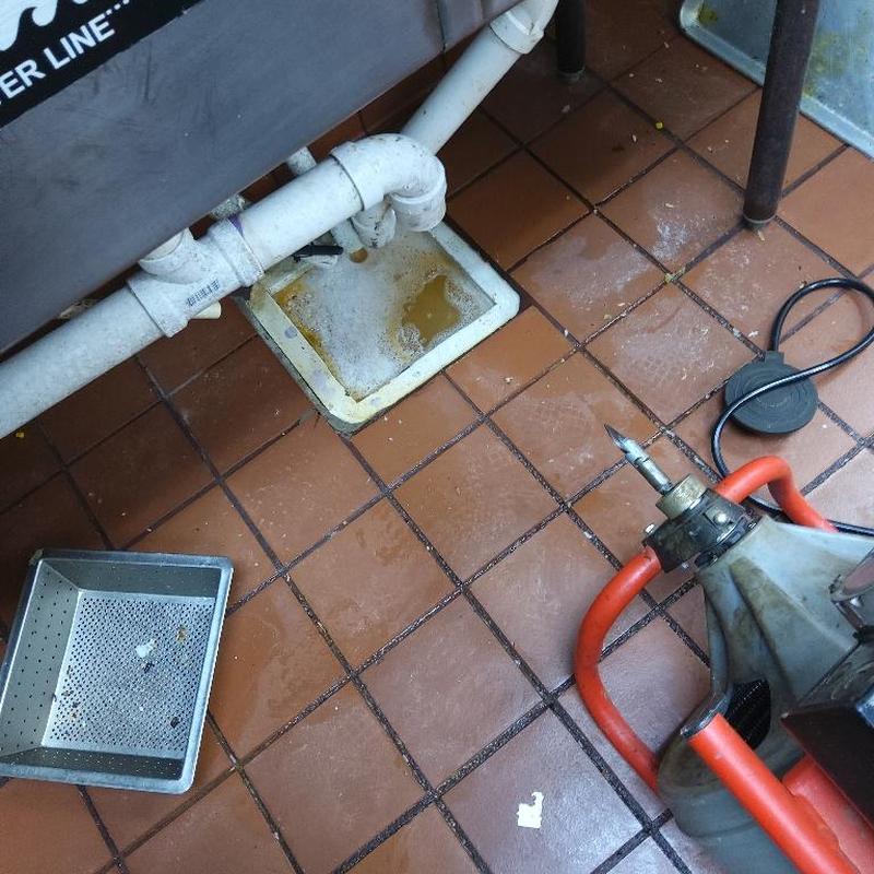 Restaurant floor drain with plumbing and cleaning tool
