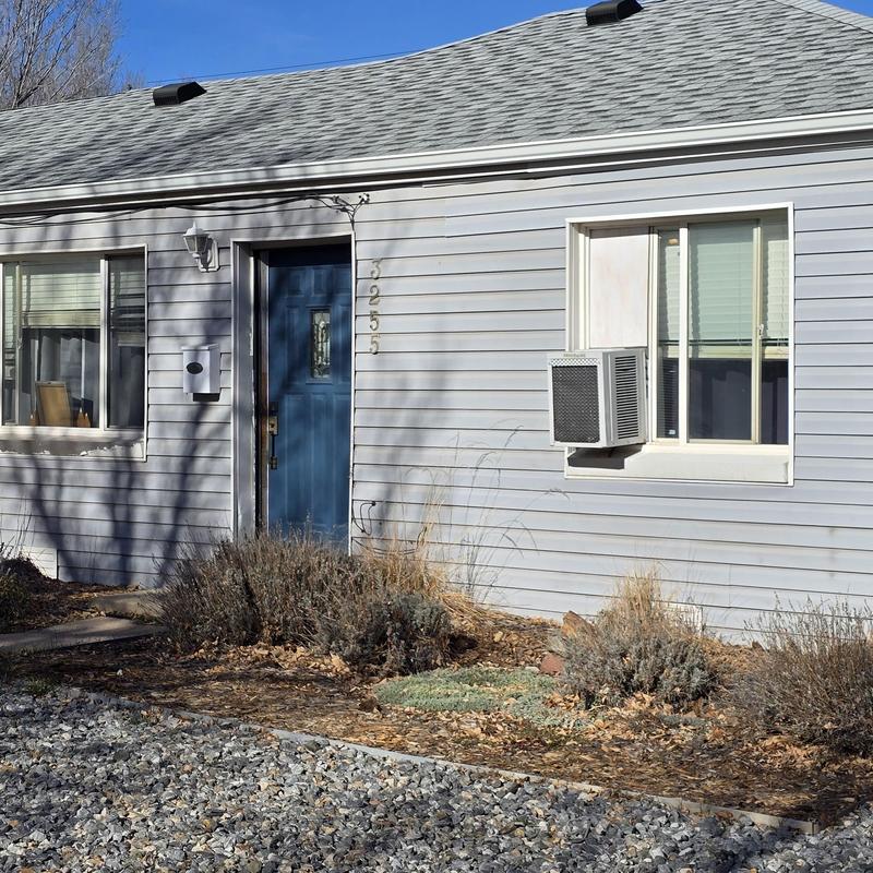Window air conditioner unit installed in house exterior Window air conditioner unit installed in house exterior