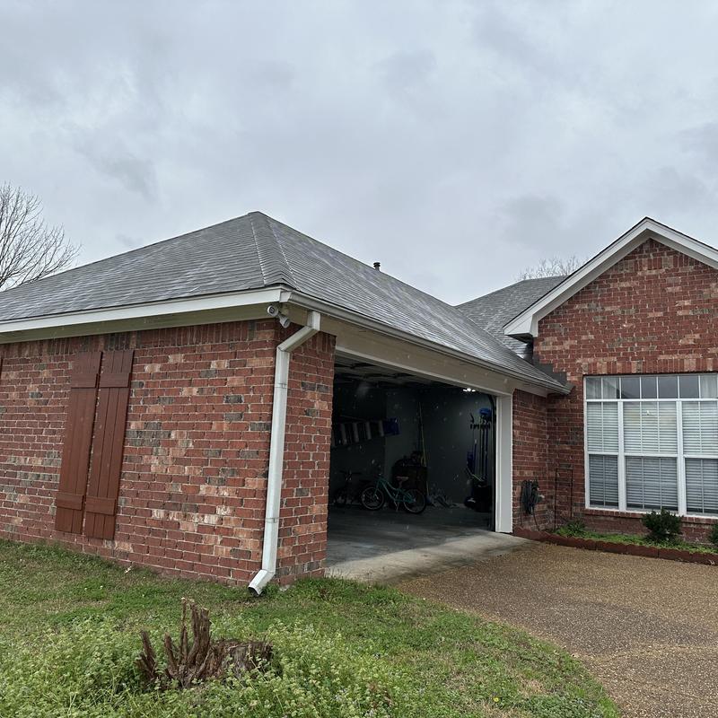 Roof shingles and gutter inspection on brick garage