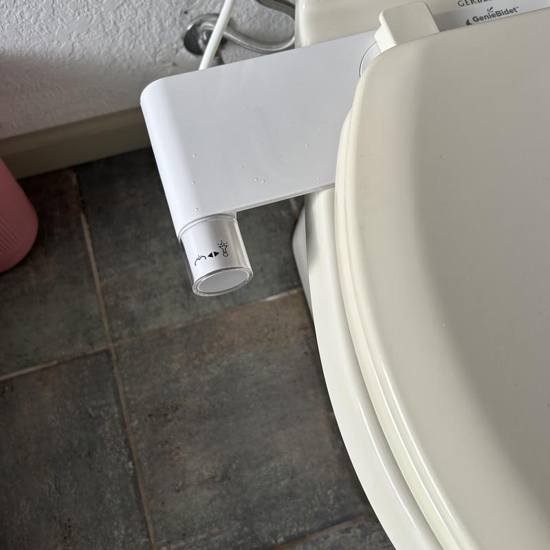 Bidet attachment installed on toilet seat control panel