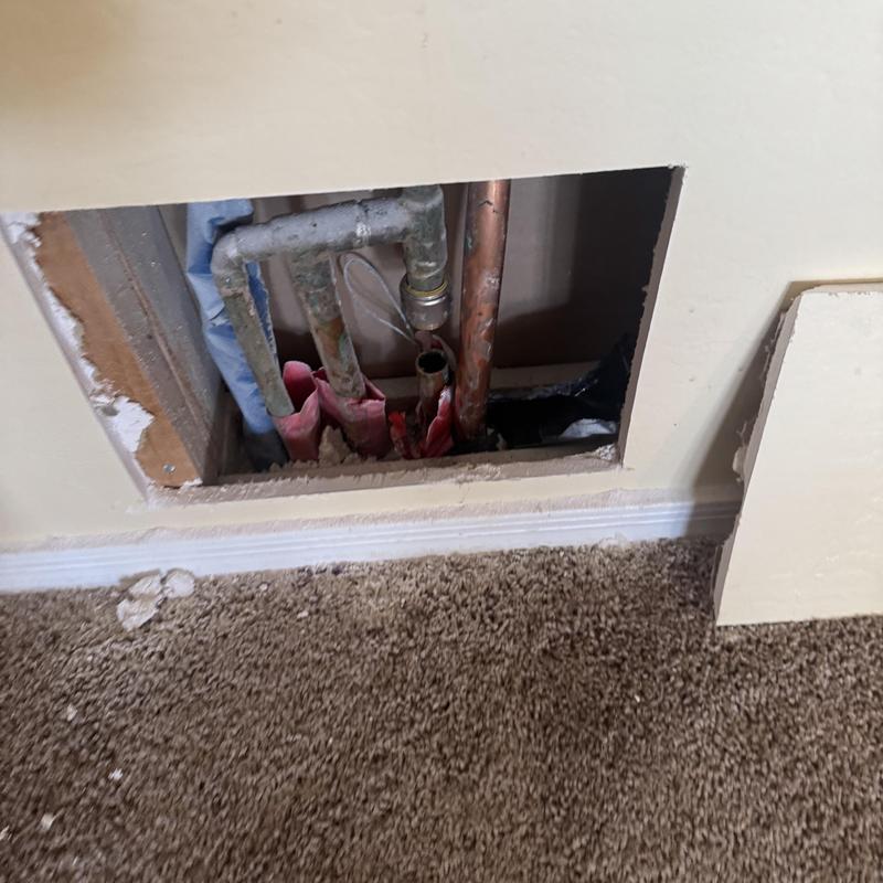 Copper and galvanized pipes exposed in wall cavity