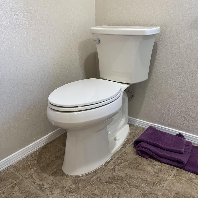 Two-piece white toilet installed on tile floor