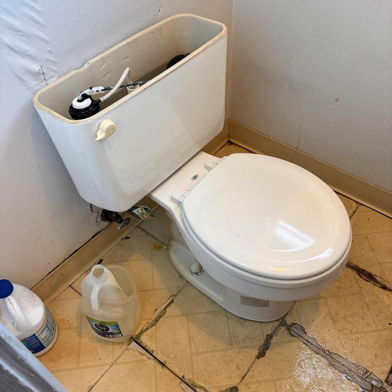 Toilet tank flush valve repair in cracked bathroom floor