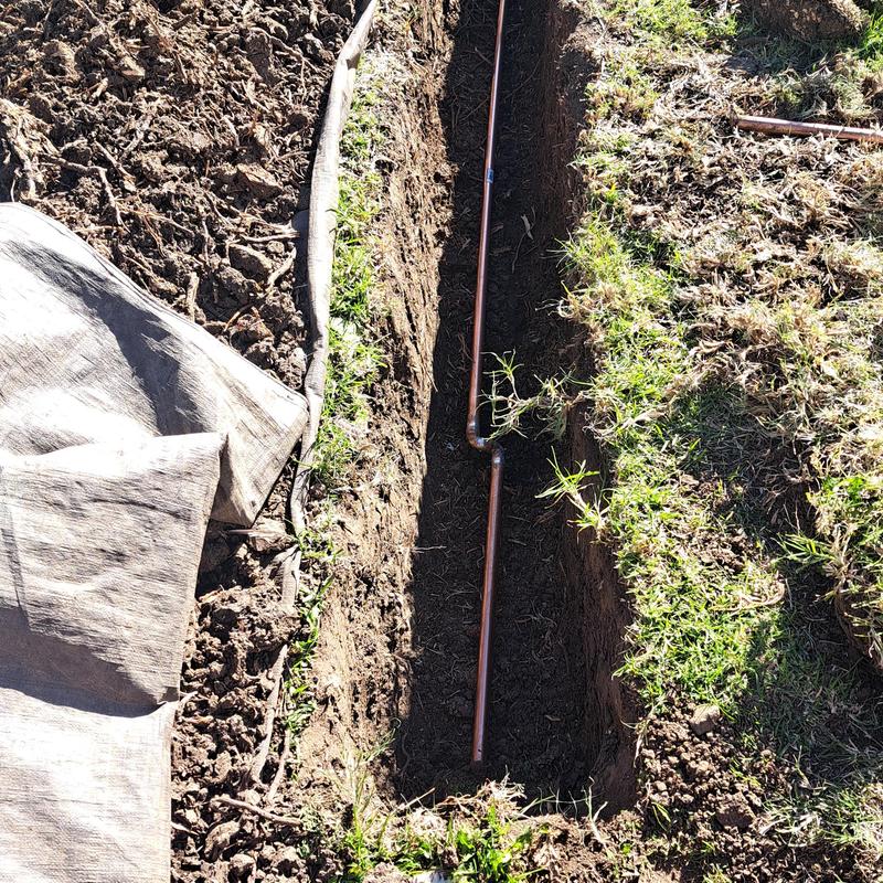 Copper water main pipe in ground trench installation Copper water main pipe in ground trench installation