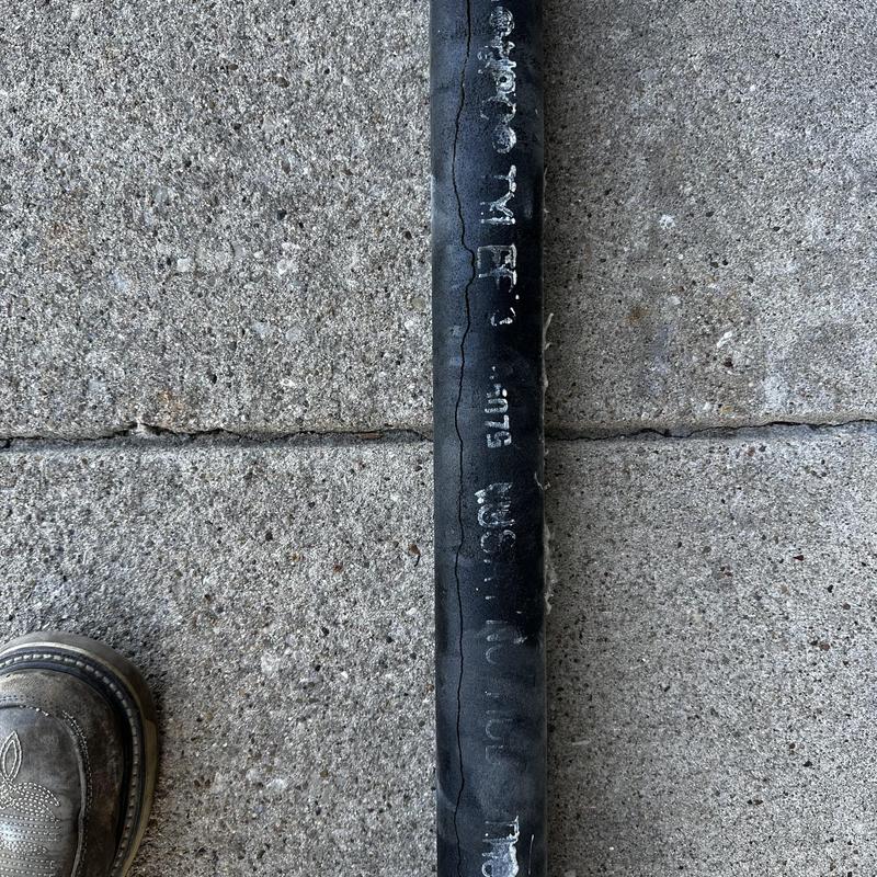 Cast-iron vent pipe with large vertical crack on concrete