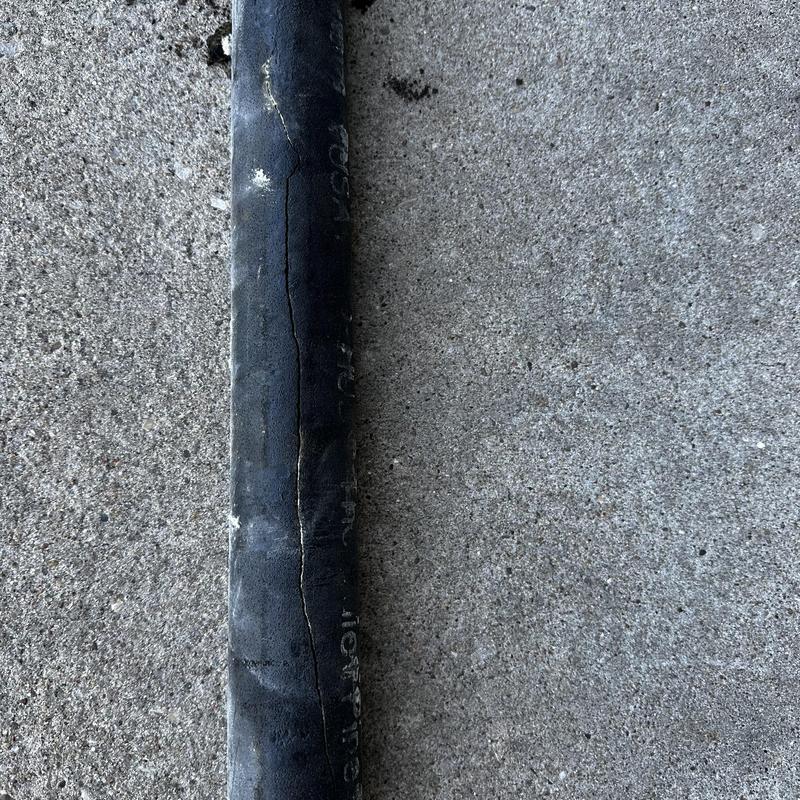 Cracked cast-iron vent pipe section on concrete