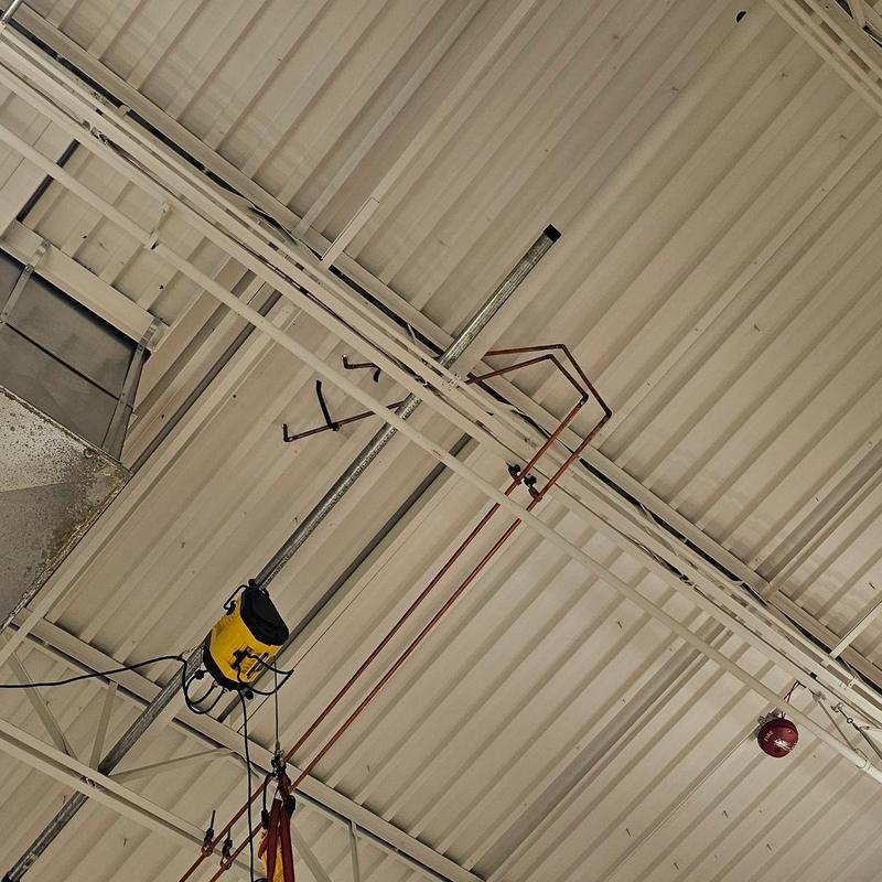 Metal roof panels with overhead crane system and piping Metal roof panels with overhead crane system and piping