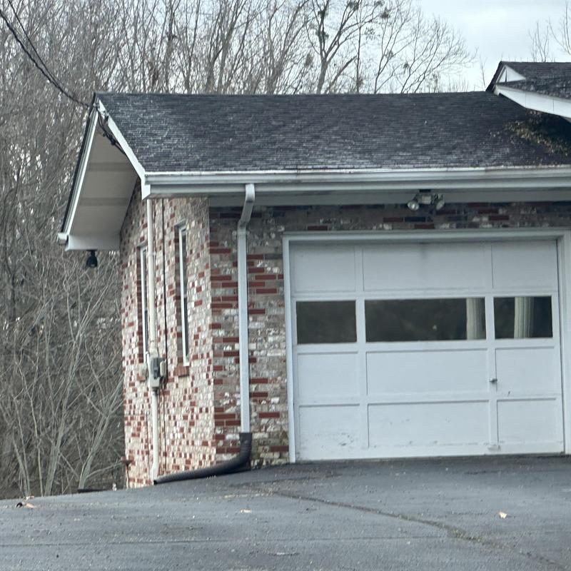 Asphalt shingle roof and gutter on brick garage