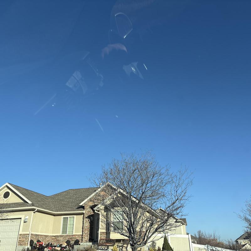 Asphalt shingle roof on residential house under clear sky Asphalt shingle roof on residential house under clear sky
