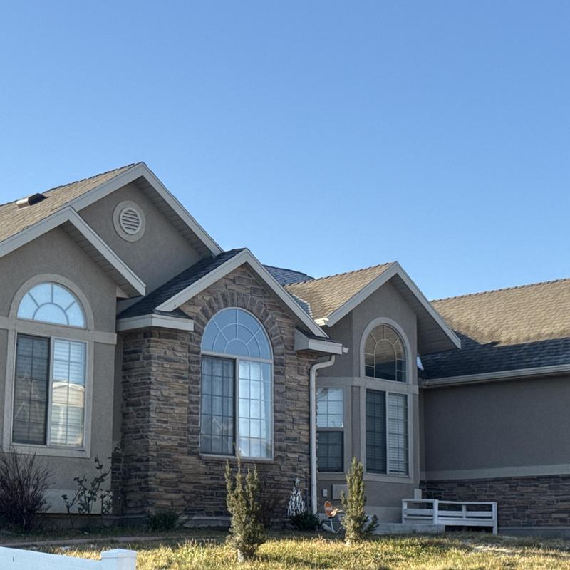 Asphalt shingle roof on residential home under clear sky Asphalt shingle roof on residential home under clear sky