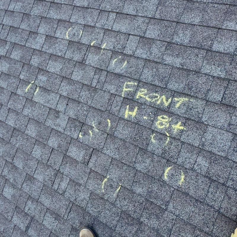 Roof shingles with hail damage marked in yellow chalk