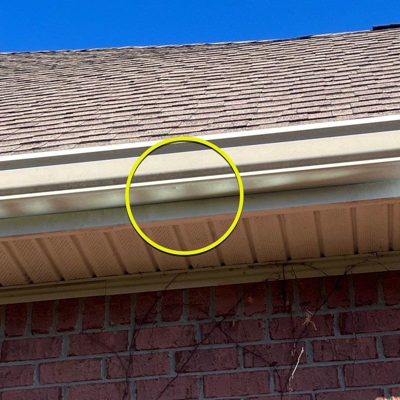 Gutter with dented section highlighted by yellow circle