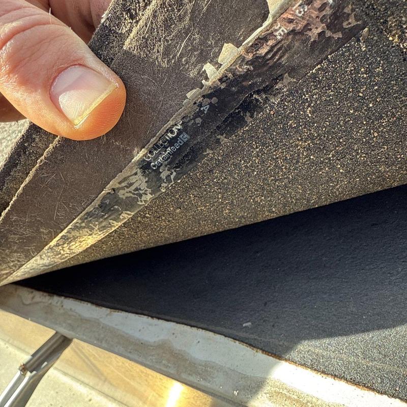 Roof membrane edge lifted for inspection of underlying surface