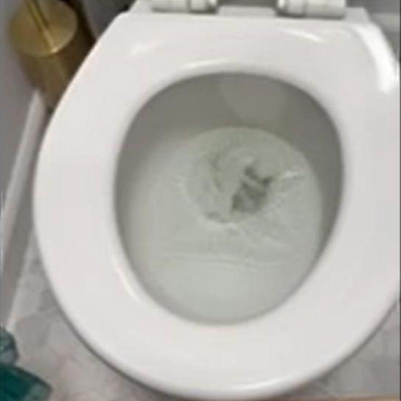 Toilet bowl flushing with water flow in bathroom
