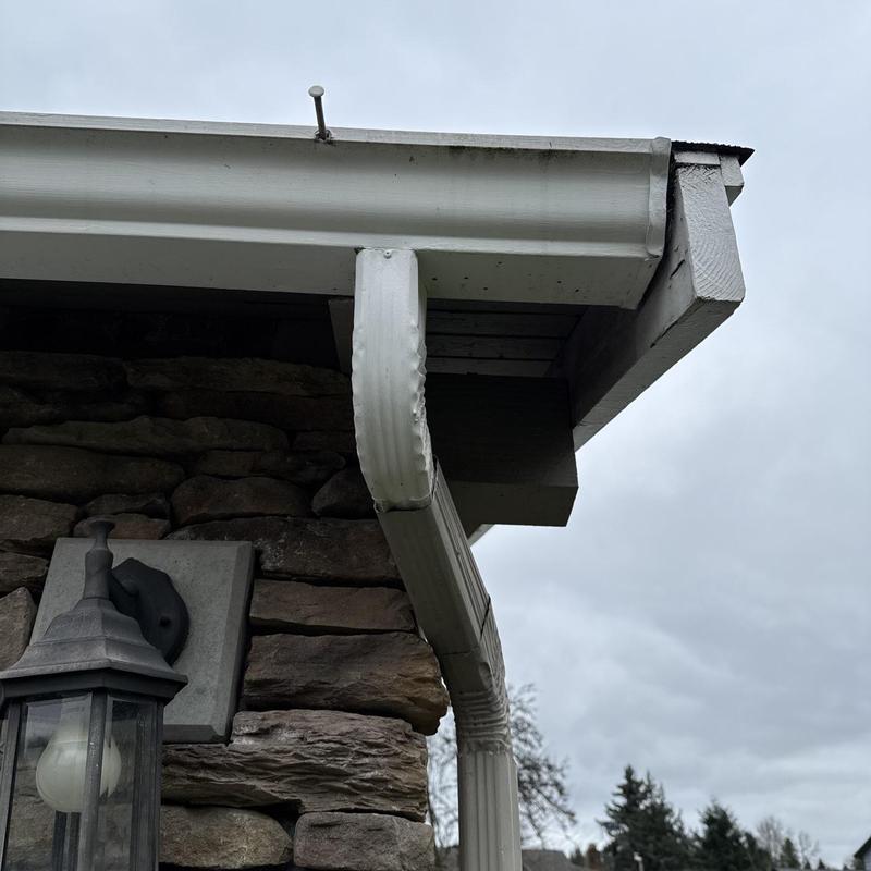Gutter and downspout inspection on stone exterior