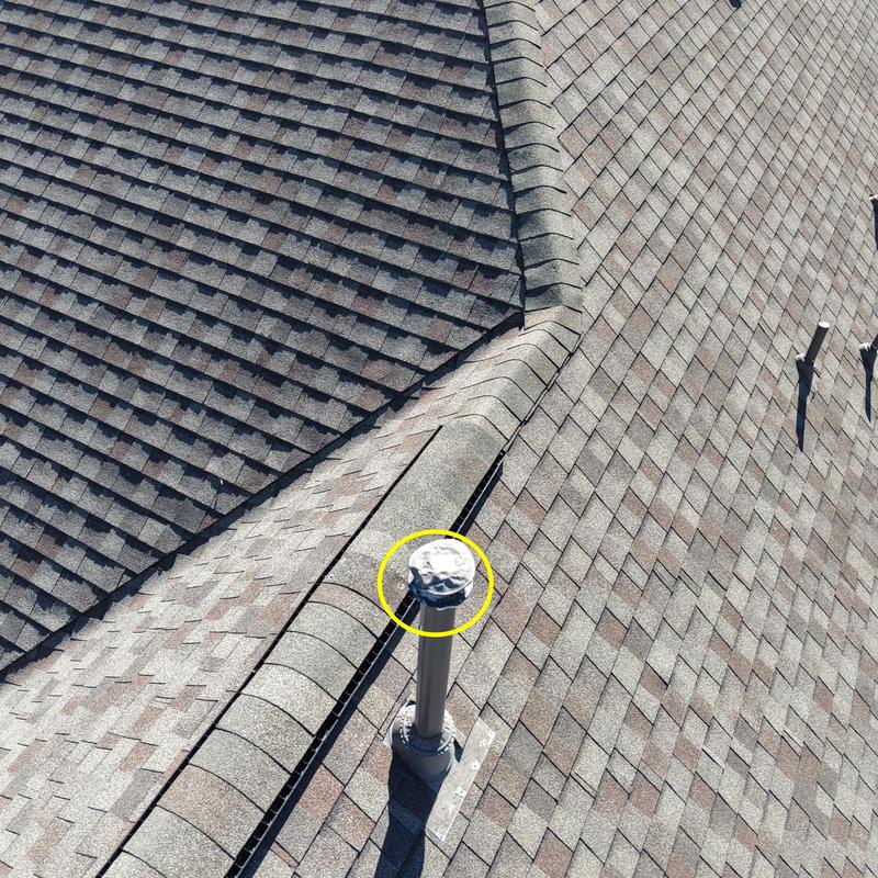 Asphalt shingle roof with hail damage on vent pipe