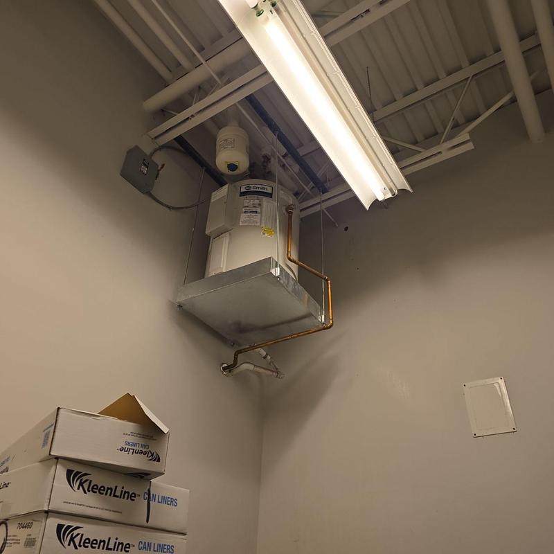 Water heater installation with exposed piping and electrical panel Water heater installation with exposed piping and electrical panel