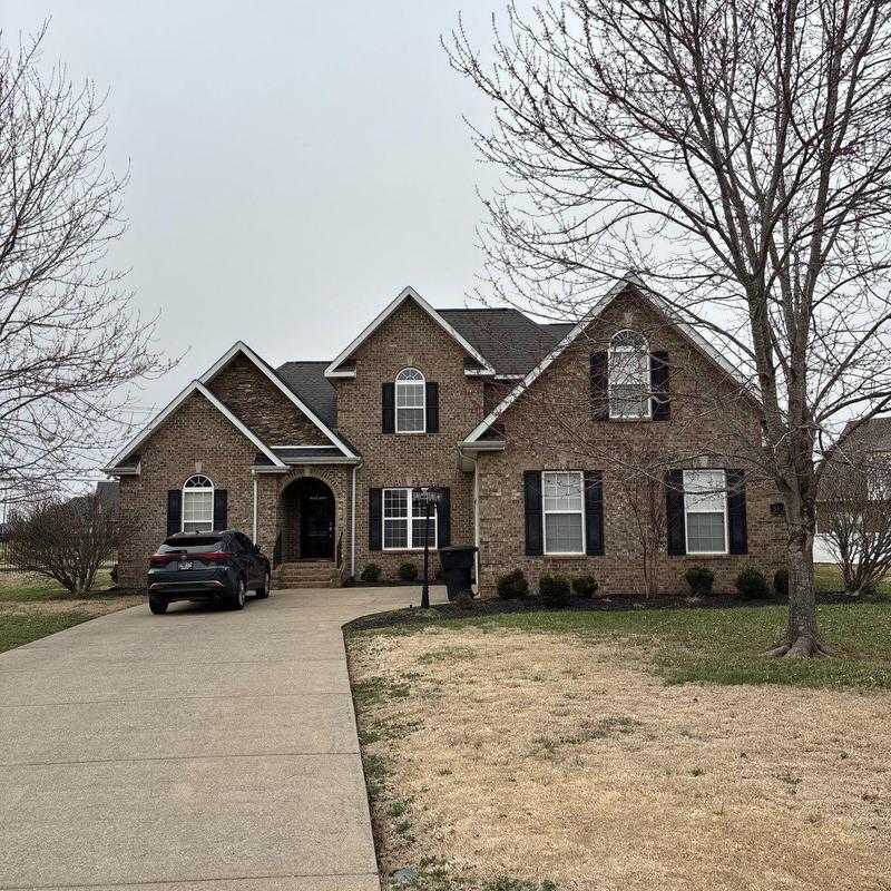 Roof shingles with hail damage on brick house