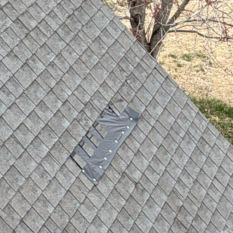 Roof shingles with hail damage and repair patch