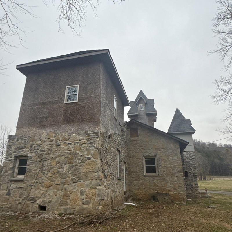 Schoolhouse stone and shingle roof with hail damage