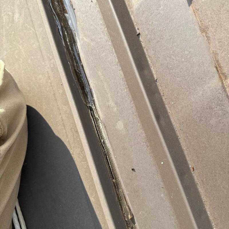 Metal roof panel seam with sealant application