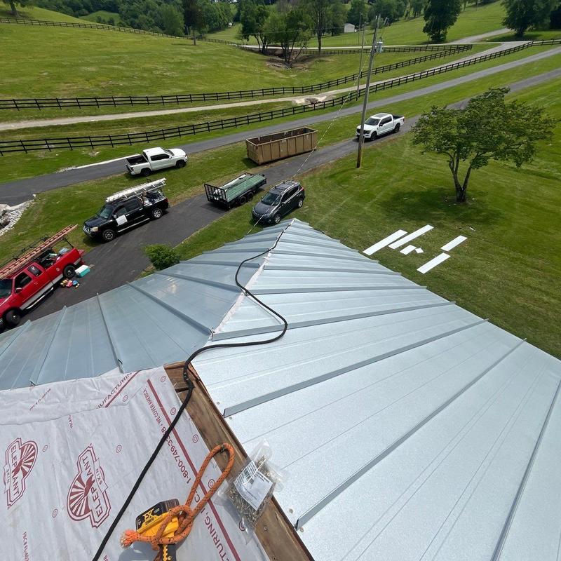Metal standing seam roof panel installation from rooftop view