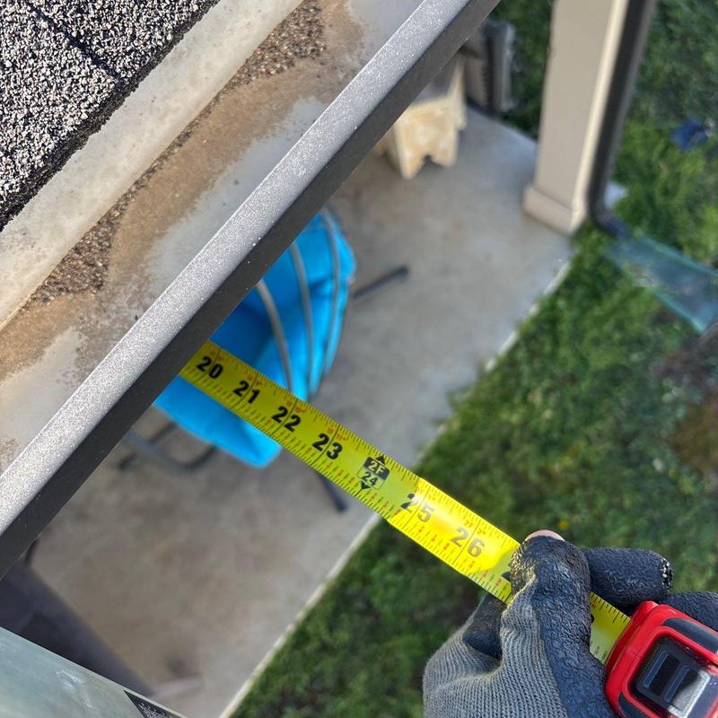 Roof gutter measurement with tape during inspection