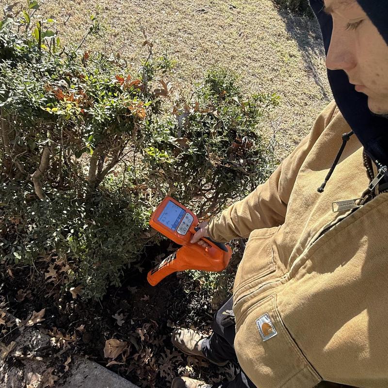 Sewer line camera inspection near shrubbery outdoors