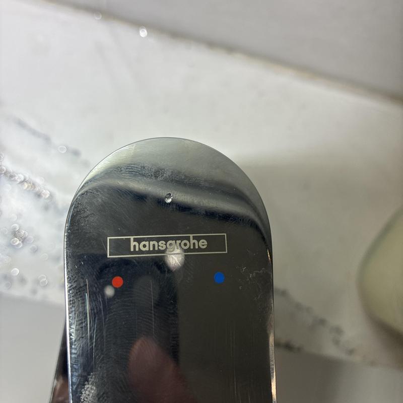 Hansgrohe shower faucet handle close-up with water droplets
