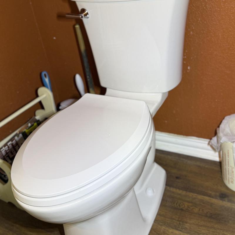 Toilet with closed lid in bathroom corner