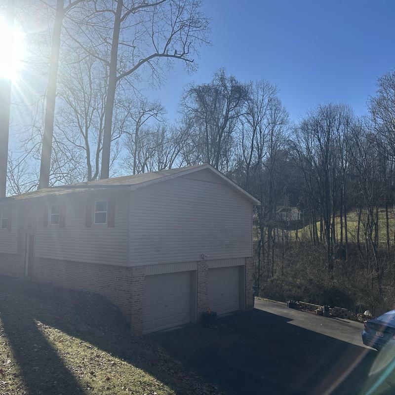 Asphalt roof on residential garage house with sun glare