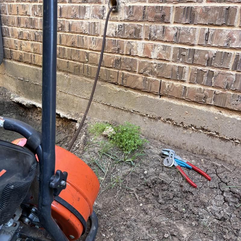 Kitchen sink drain auger and plumbing tools outdoors