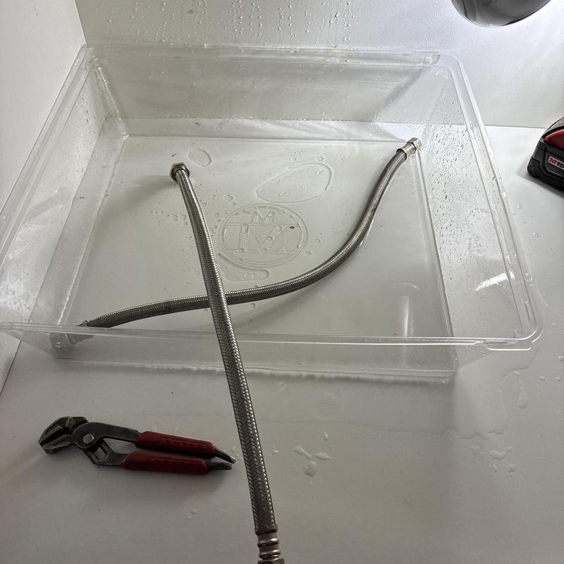 Bathroom sink hot water supply line in plastic tub