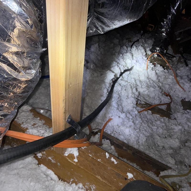 Gas lines in attic with insulation and wooden supports