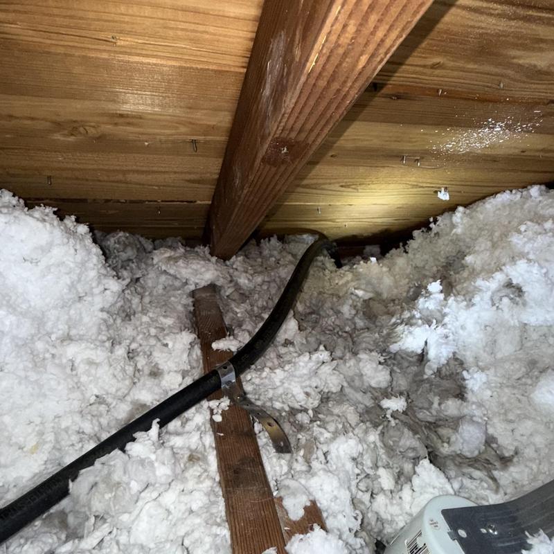 Gas line installation with attic insulation and wood beams