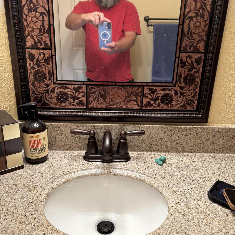 Bathroom faucet with oil-rubbed bronze handles on granite counter