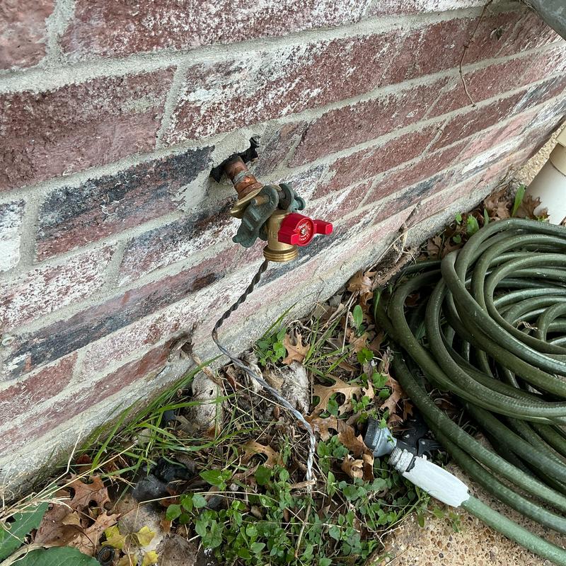 Quarter turn hose bib with garden hose attached outdoors