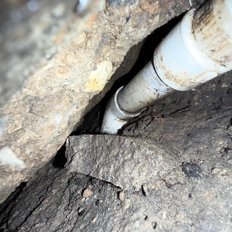 Water line pipe in yard with soil and concrete