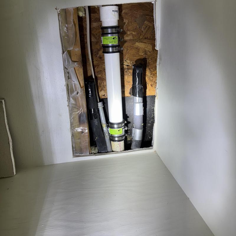 Drain pipe inside wall with repair clamps and insulation