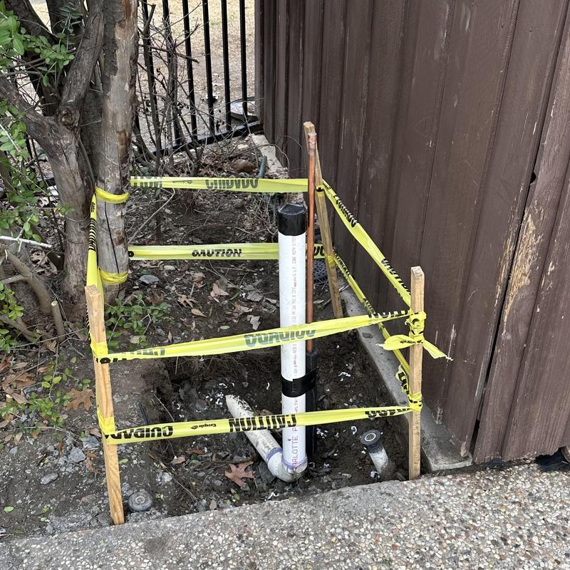 Water line pipe with caution tape at repair site