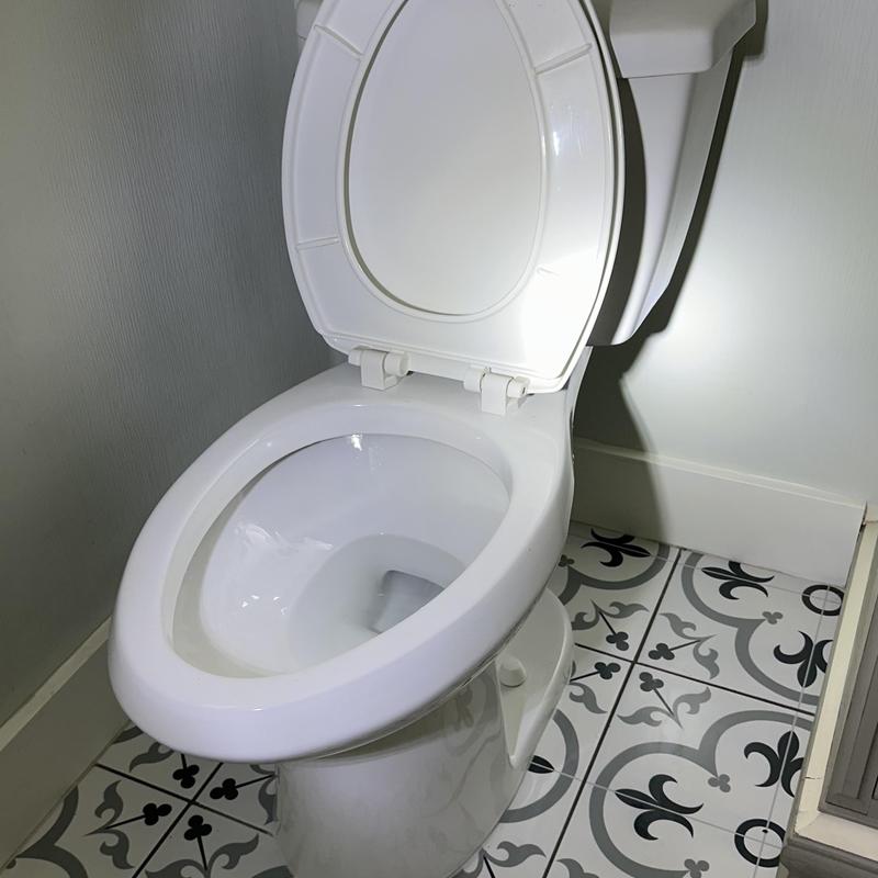 Toilet with open lid on patterned bathroom floor