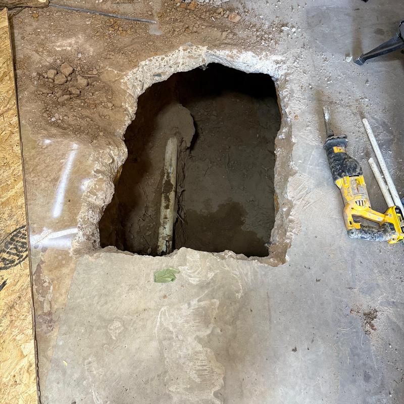 Main sewer line exposed under garage concrete slab