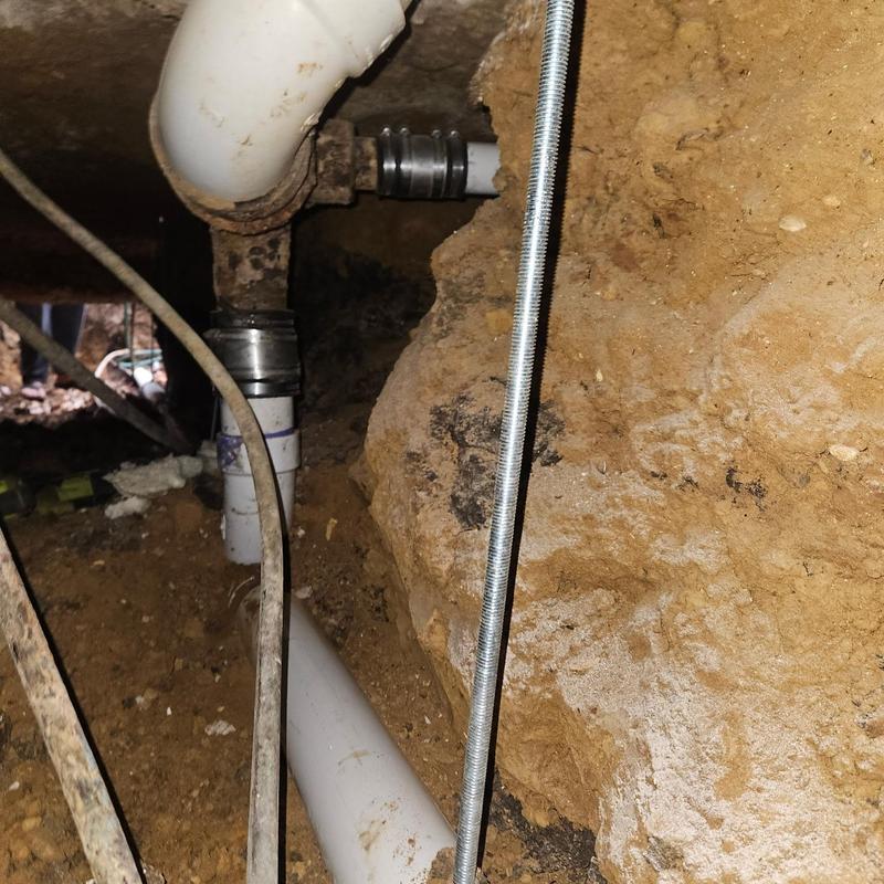 Horizontal sewer lines under home with pipe fittings